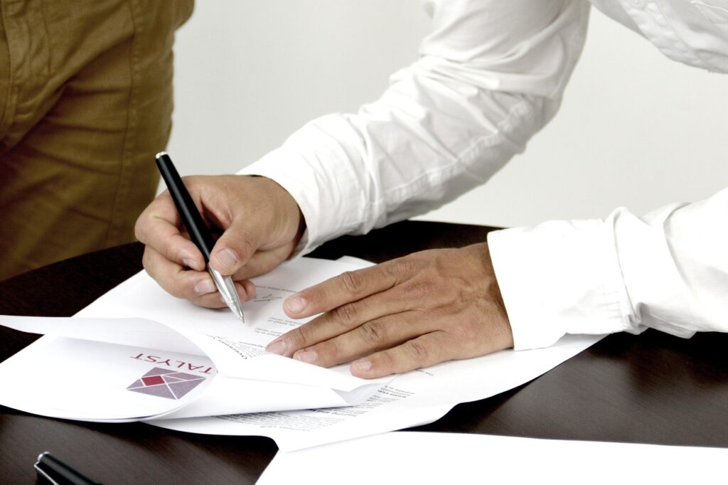 Image of man's hands signing a legal document | Angela Griffith Law